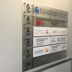 Innen-Sammelwegweiser zur Stockwerkbezeichnung aus edlen Glasschildern mit weißer Folienschrift in Chemnitz.