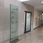 Eleganter Innenwegweiser als Glasstele mit kontrastreicher Folienschrift für ein Ärztehaus in Düsseldorf.