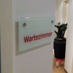 Elegantes Praxis-Türschild aus satiniertem Echtglas mit kontraststarker Folienschrift in Karlsruhe.